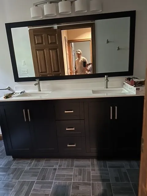 Espresso double vanity with a light stone top and a wide mirror