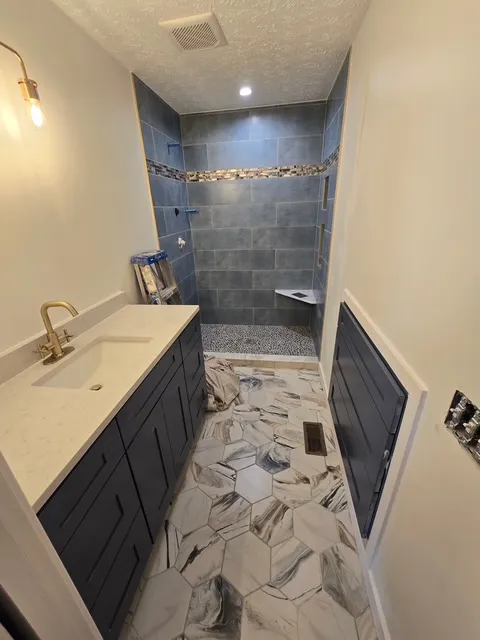 Navy vanity with a gold tap and marble top