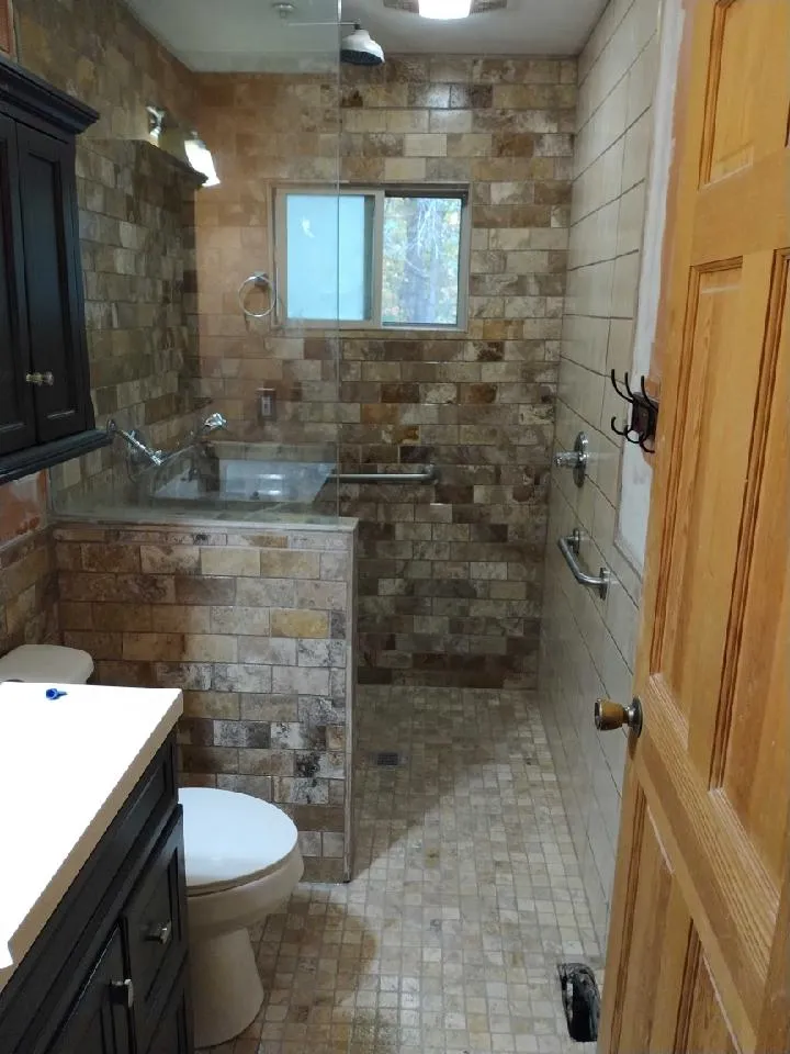 Stone-tiled shower behind glass