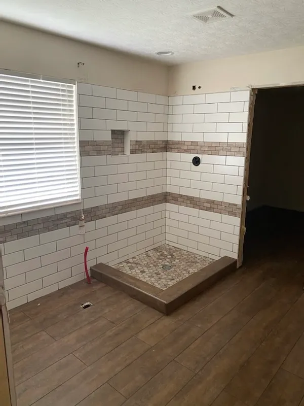 Subway tile shower with a pebble border