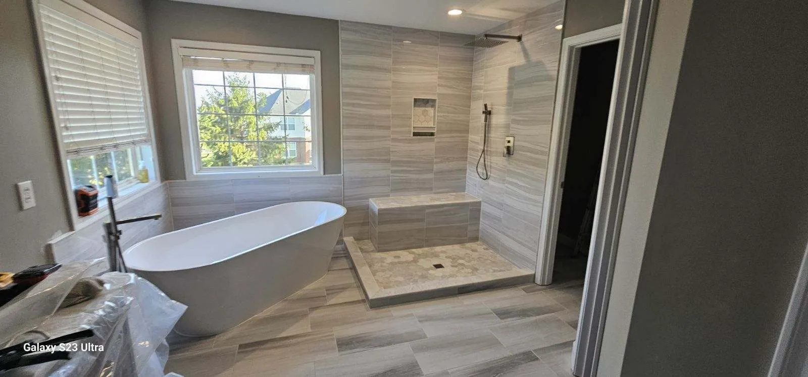 Bathroom with a freestanding tub beside a walk-in shower