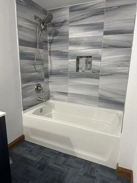 Marbled tile tub surround running to the ceiling