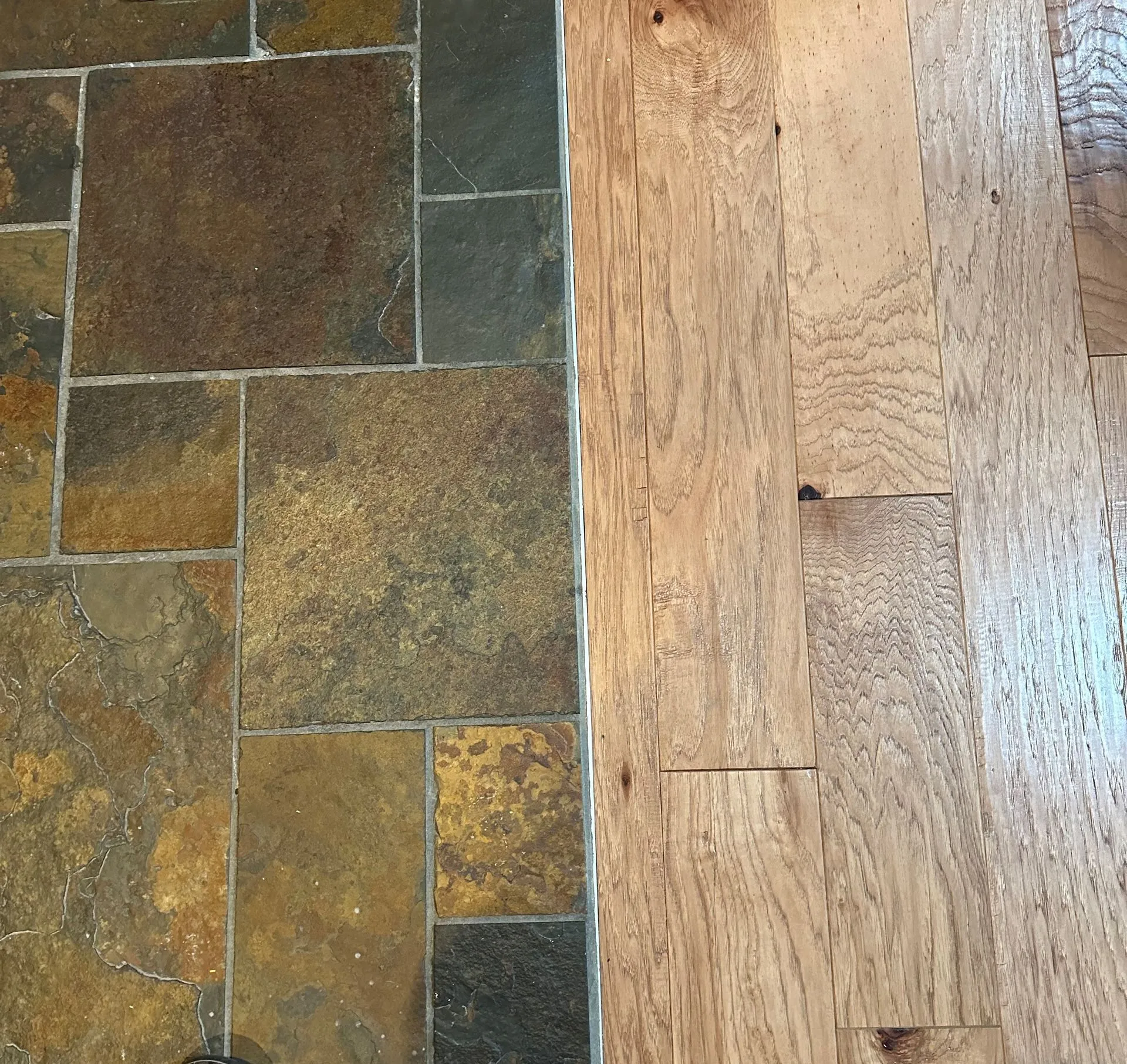 Multi-tone slate tile meeting hickory hardwood in a flush transition