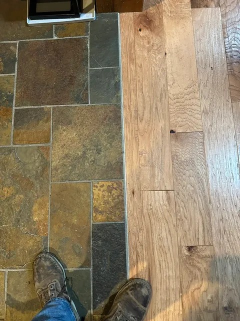 Slate tile meeting wood flooring in a clean transition