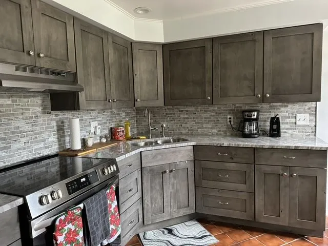 Grey shaker cabinets with a stacked stone backsplash