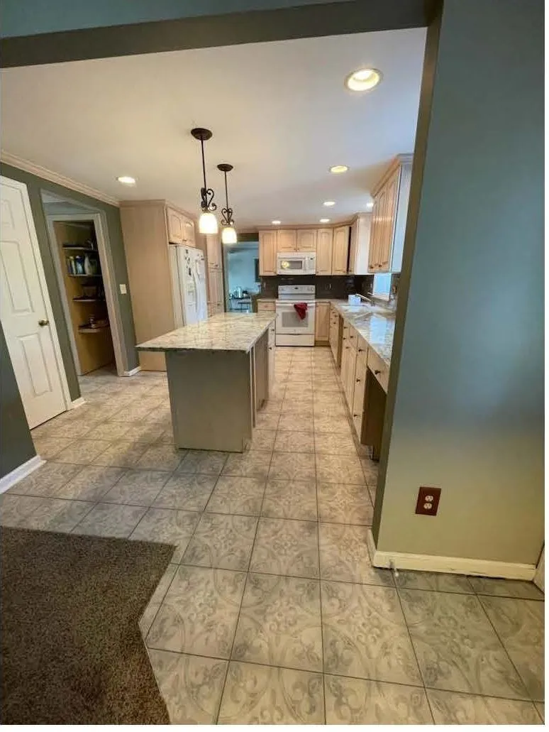 Maple cabinets and a granite island in an open kitchen